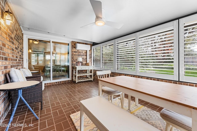 dining space featuring ceiling fan, brick wall, and a wall mounted AC