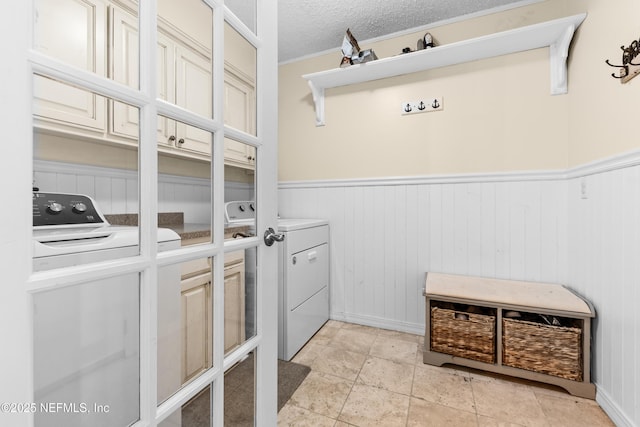 laundry room with independent washer and dryer and a textured ceiling