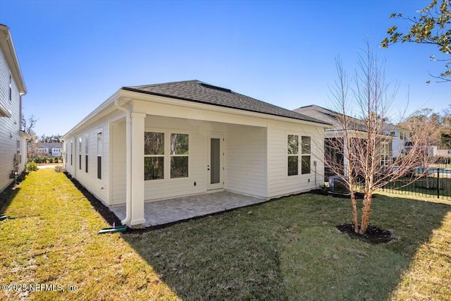 rear view of property with a lawn and a patio