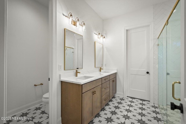 bathroom with vanity, toilet, and a shower with shower door