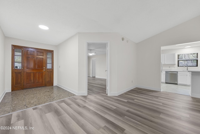 entryway featuring lofted ceiling, sink, and light hardwood / wood-style floors