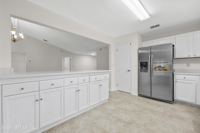 kitchen featuring stainless steel refrigerator with ice dispenser, lofted ceiling, decorative light fixtures, and white cabinets