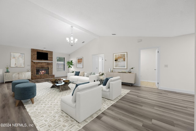 living room featuring lofted ceiling with beams, an inviting chandelier, hardwood / wood-style floors, and a brick fireplace