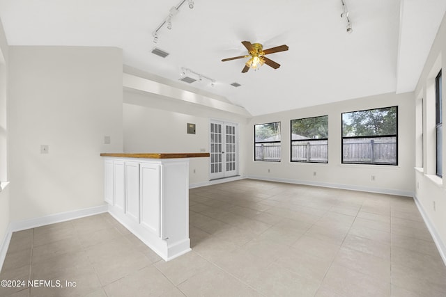 unfurnished room with lofted ceiling, light tile patterned floors, and ceiling fan