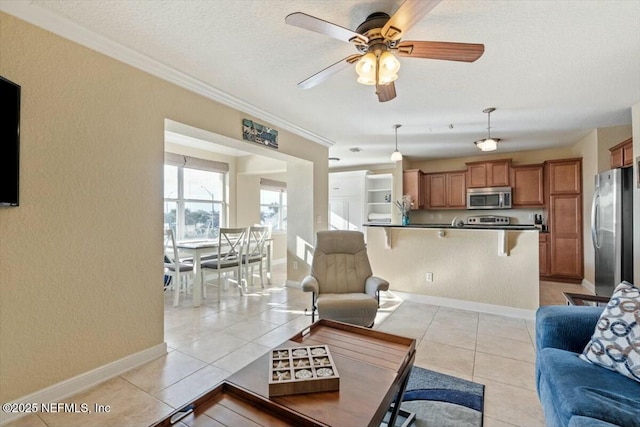 living room featuring light tile patterned floors, crown molding, a textured ceiling, and ceiling fan