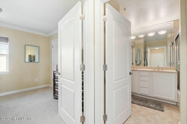 bathroom featuring vanity, crown molding, tile patterned floors, and a textured ceiling