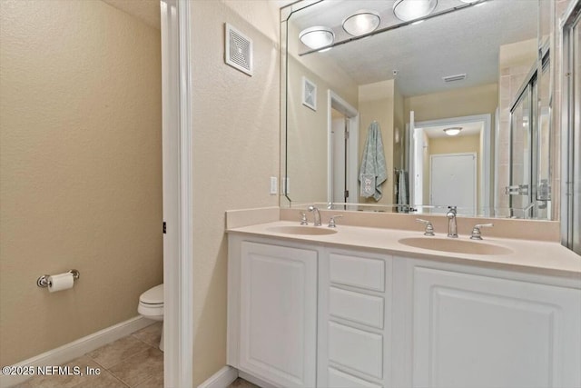 bathroom featuring vanity, toilet, and tile patterned flooring