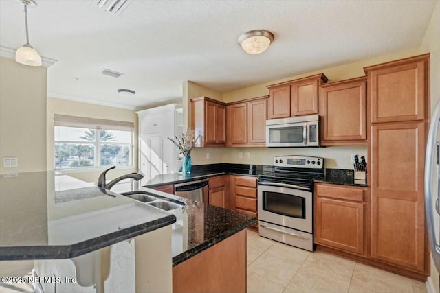 kitchen featuring sink, appliances with stainless steel finishes, light tile patterned flooring, decorative light fixtures, and kitchen peninsula