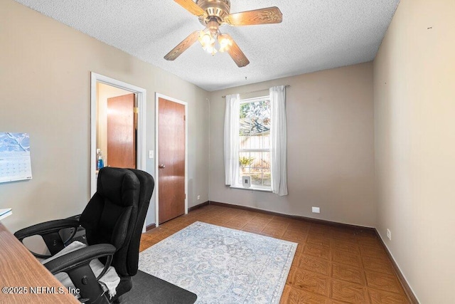 home office featuring ceiling fan and a textured ceiling