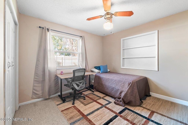 bedroom featuring ceiling fan, light carpet, and a textured ceiling