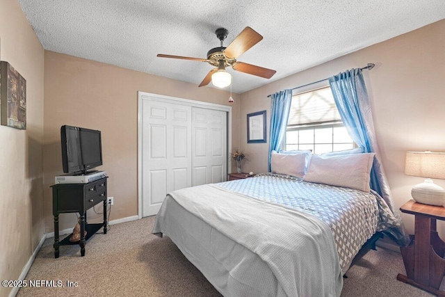 bedroom featuring ceiling fan, light carpet, a closet, and a textured ceiling