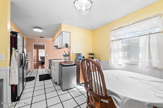 dining space with light tile patterned flooring and a textured ceiling