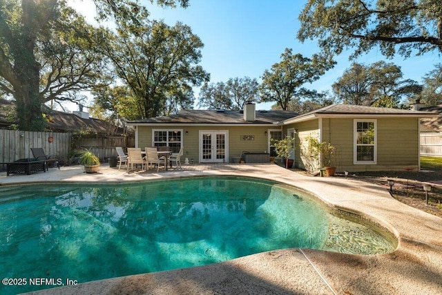 view of swimming pool featuring french doors and a patio area