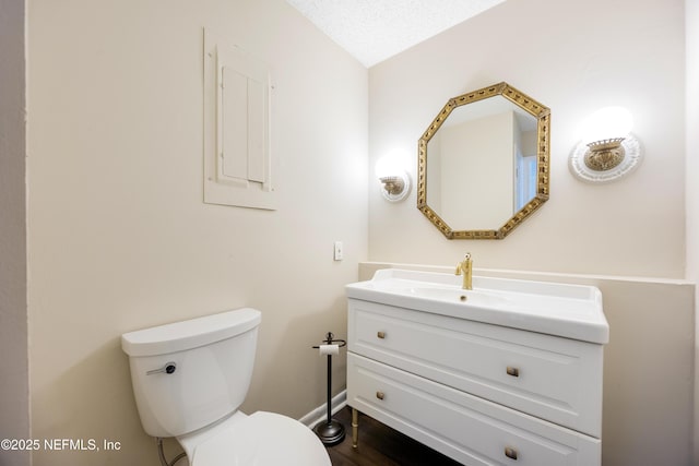 bathroom featuring vanity, a textured ceiling, and toilet