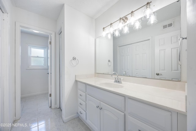 bathroom with vanity, tile patterned floors, and a textured ceiling