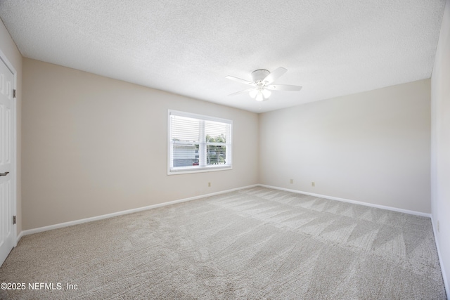 carpeted spare room featuring ceiling fan and a textured ceiling