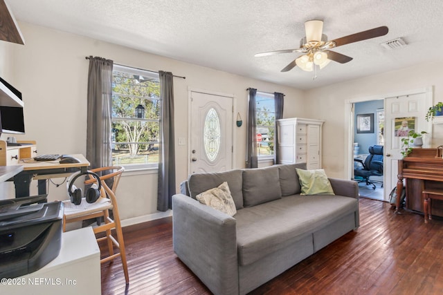 living room with ceiling fan, dark wood-type flooring, and a textured ceiling