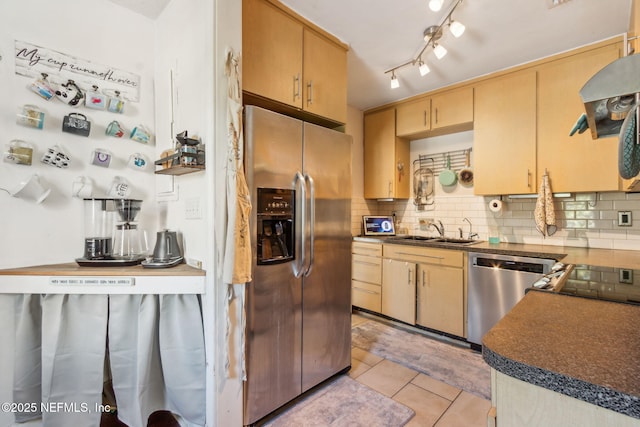 kitchen featuring tasteful backsplash, light tile patterned flooring, appliances with stainless steel finishes, and sink