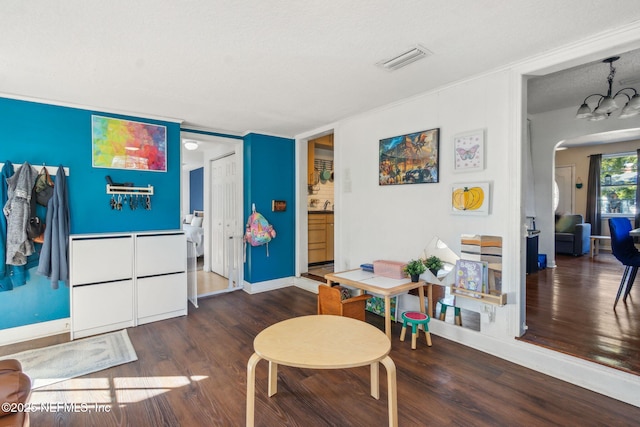 rec room featuring dark wood-type flooring and a notable chandelier