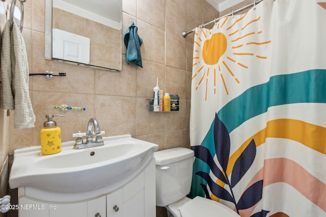 bathroom featuring vanity, toilet, a shower with shower curtain, and tile walls