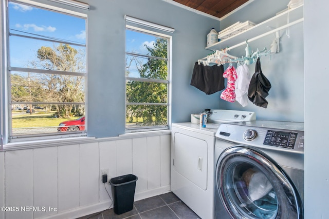 washroom with separate washer and dryer and dark tile patterned flooring