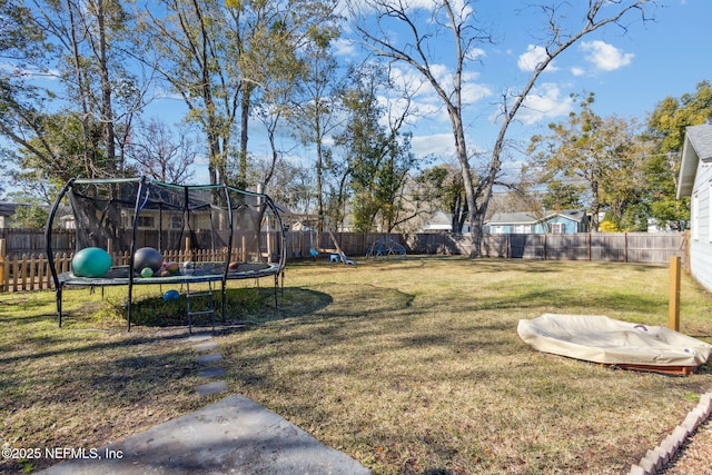 view of yard with a playground and a trampoline