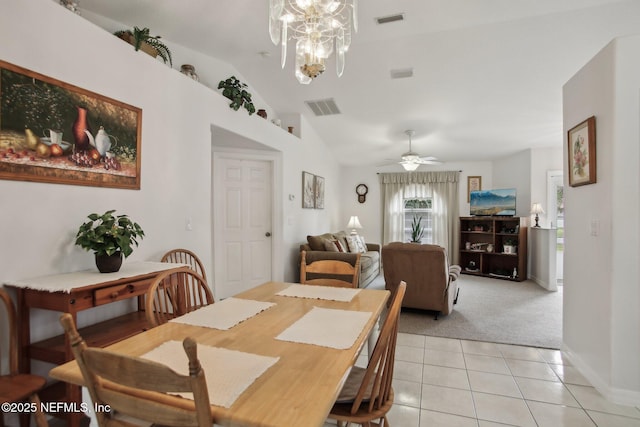 dining space with vaulted ceiling, ceiling fan with notable chandelier, and light tile patterned floors