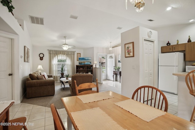 tiled dining area with ceiling fan and lofted ceiling