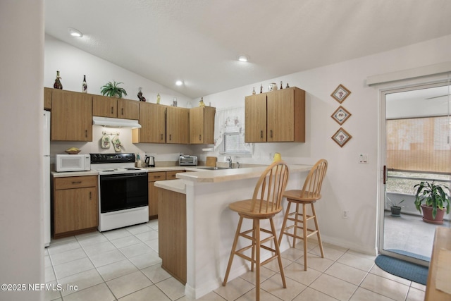 kitchen with light tile patterned flooring, sink, a kitchen breakfast bar, kitchen peninsula, and white appliances