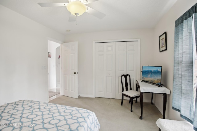 bedroom with light carpet, ceiling fan, and a closet