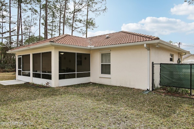 rear view of property with a sunroom and a yard