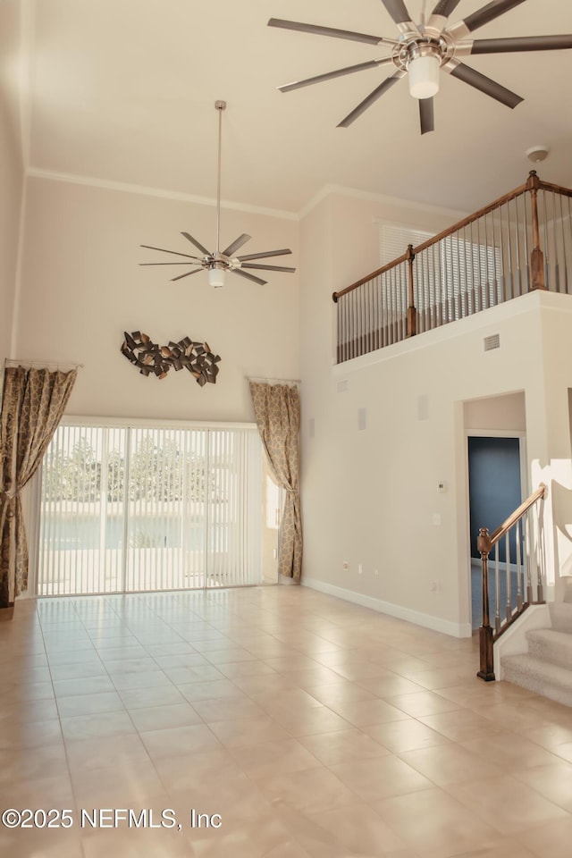 unfurnished living room featuring a high ceiling, ornamental molding, light tile patterned flooring, and ceiling fan