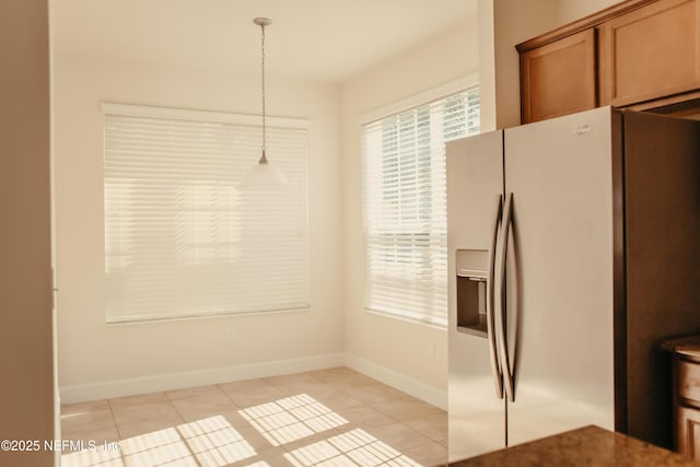 kitchen featuring light tile patterned flooring, decorative light fixtures, and stainless steel fridge with ice dispenser