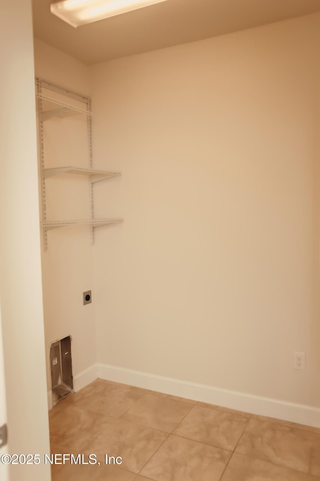 laundry area with tile patterned flooring and hookup for an electric dryer