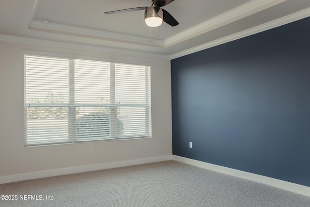 unfurnished room with crown molding, ceiling fan, a raised ceiling, and carpet