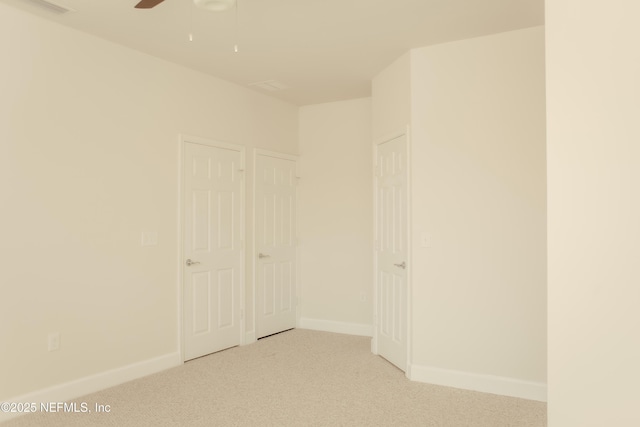 interior space with light colored carpet and ceiling fan