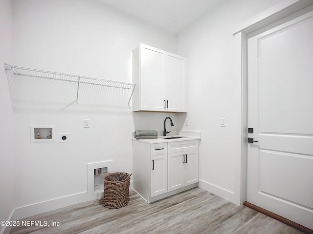 clothes washing area with sink, cabinets, light hardwood / wood-style flooring, hookup for a washing machine, and electric dryer hookup