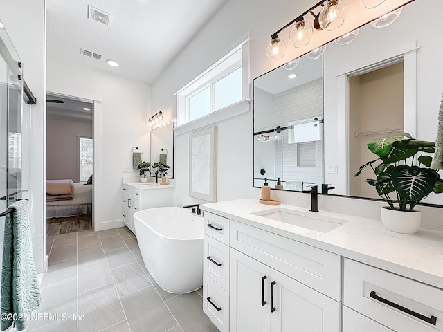 bathroom with vanity, plenty of natural light, tile patterned floors, and plus walk in shower