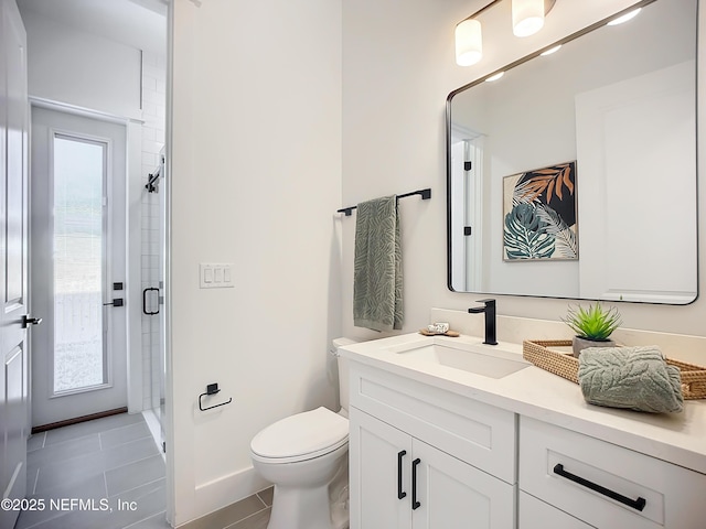 bathroom with an enclosed shower, vanity, tile patterned floors, and toilet