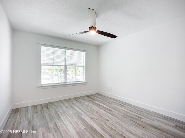 spare room with ceiling fan, light hardwood / wood-style floors, and a textured ceiling