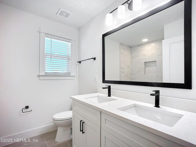 bathroom with tile patterned floors, vanity, toilet, and a shower