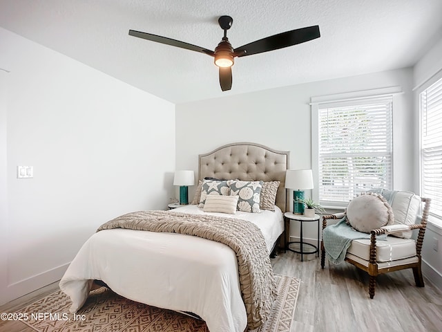 bedroom with hardwood / wood-style floors, a textured ceiling, and ceiling fan