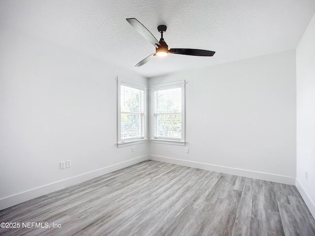 empty room with ceiling fan, light hardwood / wood-style flooring, and a textured ceiling