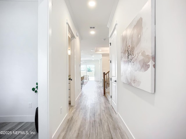 hallway featuring crown molding and light wood-type flooring