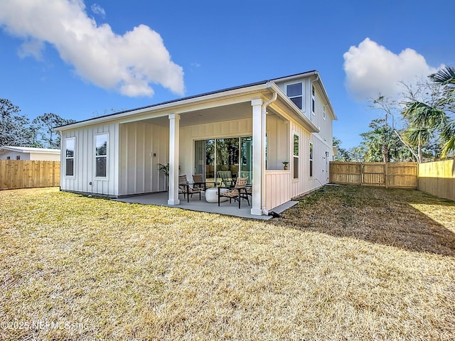 back of property with a patio area and a lawn