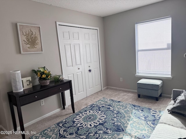 bedroom featuring light colored carpet, a closet, and a textured ceiling