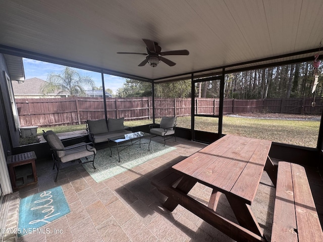 sunroom / solarium featuring ceiling fan