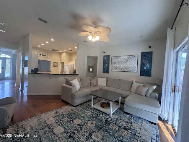 living room with hardwood / wood-style flooring, ceiling fan, a healthy amount of sunlight, and a textured ceiling