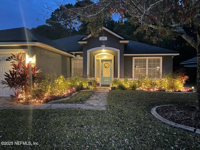 view of front of property featuring a garage and a front lawn