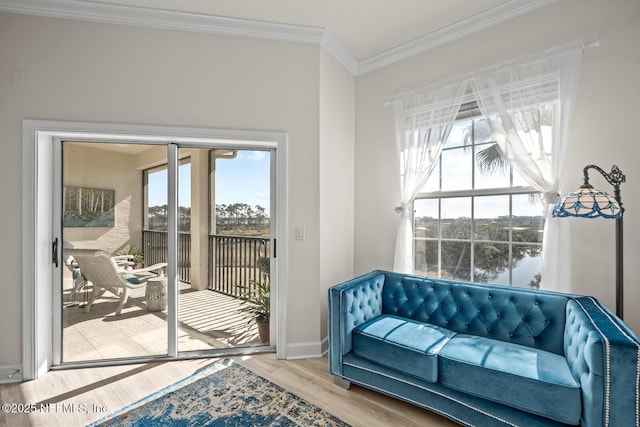 sitting room with hardwood / wood-style floors and crown molding